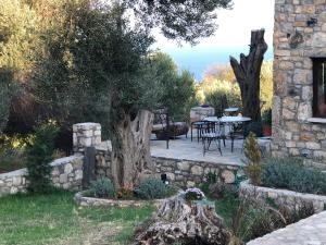 卡拉布倫的住宿－Toscany house in Tepeboz, Izmir，一座花园,花园内拥有石墙、桌子和一棵树