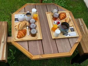 una mesa de madera con dos platos de comida y cruasanes en Guestroom Boiscommun, 1 pièce, 2 personnes - FR-1-590-268 en Combreux