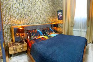 um quarto com uma cama com um edredão azul em Very comfortable apartment, convenient location! em Baku