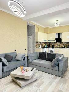 uma sala de estar com um sofá e uma mesa de centro em Very comfortable apartment, convenient location! em Baku