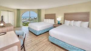 a hotel room with two beds and a view of the ocean at El Caribe Resort and Conference Center in Daytona Beach