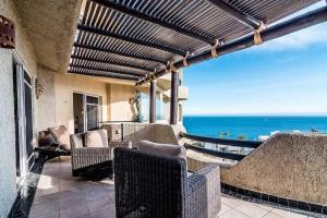 a patio with chairs and a view of the ocean at Oceanfront Penthouse, 2 Masters, 2 Baths, kitchen! in Cabo San Lucas