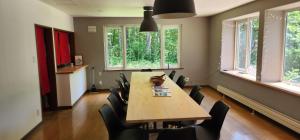 a dining room with a table and chairs and windows at El Cosmo Lodge, Niseko in Niseko