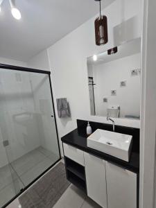 a white bathroom with a sink and a shower at Flat Maravilhoso - Metrô - USP - Butantã in Sao Paulo