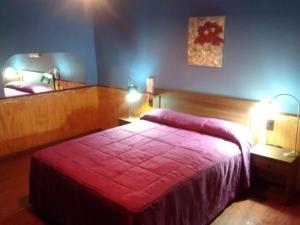 - une chambre avec un lit et une couverture rouge dans l'établissement Hostal Valle Central San Fernando, Chile, à San Fernando