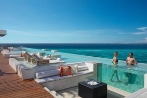 zwei Personen sind im Wasser in einem Resort in der Unterkunft Impression Isla Mujeres by Secrets - Adults Only - All Inclusive in Isla Mujeres