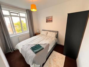 a small bedroom with a bed and a window at Neasden, Dollis Hill London Apartment in London