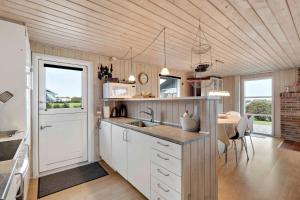 una cucina con lavandino e bancone con tavolo di Fantastic View Over Venø Bay a Vinderup Altre 16 foto