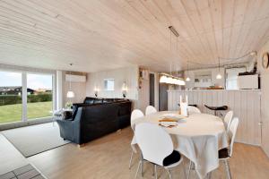 una sala da pranzo e un soggiorno con tavolo e sedie di Fantastic View Over Venø Bay a Vinderup