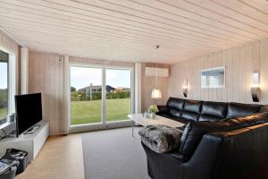 un soggiorno con un divano in pelle e una televisione di Fantastic View Over Venø Bay a Vinderup