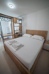 une chambre avec un grand lit avec des draps blancs dans l'établissement SeA apartments 123, à Saranda
