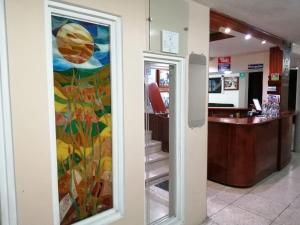 a lobby with a painting on the wall at Hostal Pucará in Loja
