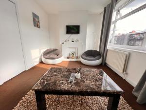 a living room with two chairs and a table at Neasden, Dollis Hill London Apartment in London