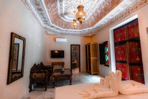 una sala de estar con techo artesonado y una habitación con sofá en Riad Deluxe, en Marrakech