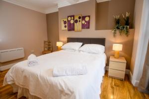a bedroom with a large white bed with two pillows at Tavmar Rooms in Lincoln