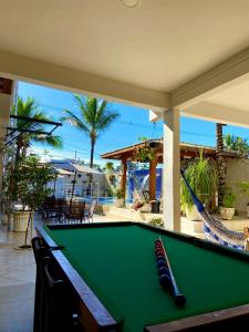 a pool table on a patio with a hammock at Barreto Hospedagem in Caraguatatuba
