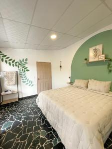 Un dormitorio con una cama grande y una pared verde. en Casa Serena B&B, en Nueva San Salvador