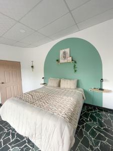 een slaapkamer met een groot bed met een blauwe muur bij Casa Serena B&B in Nueva San Salvador