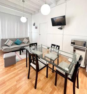 a living room with a glass table and chairs at Departamento La Punta C - Piscina - Zona parrilla in Lima