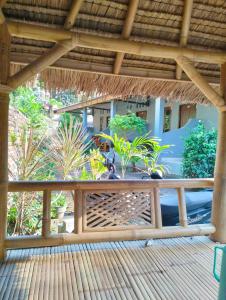 a wooden deck with a pergola and some plants at T&T Homestay in Kuta Lombok