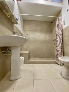a white bathroom with a sink and a shower at Espacio Planetaria in Córdoba