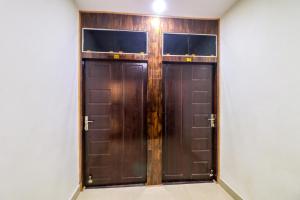two brown doors in a room with a wall at Flagship Hotel Rodstar in Chinhat