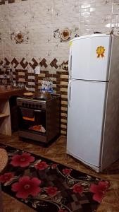 Il comprend une cuisine équipée d'un réfrigérateur blanc et d'une cuisinière. dans l'établissement شقق للايجار, 