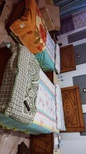 a pile of quilts sitting on top of wooden cabinets at شقق للايجار 