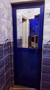une porte bleue avec un reflet dans une fenêtre dans l'établissement شقق للايجار, 