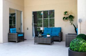 a patio with wicker chairs and a table with blue seats at Private house Kissimmee/Orlando in Kissimmee