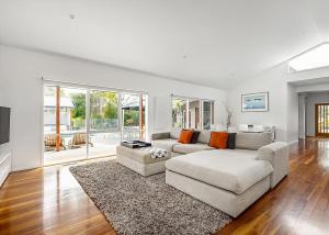 a living room with a white couch and a rug at Pool Haven on Leah in Rye