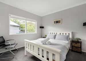 a white bedroom with a white bed and a window at Pool Haven on Leah in Rye +18 photos
