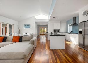 a large living room with a couch and a kitchen at Pool Haven on Leah in Rye