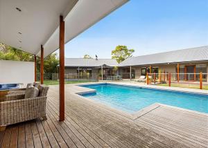 a swimming pool with a deck and a house at Pool Haven on Leah in Rye