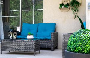 a wicker chair with blue pillows on a patio at Private house Kissimmee/Orlando in Kissimmee