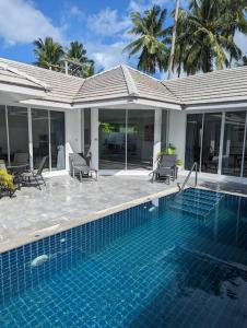 uma piscina com cadeiras e uma casa em The Oasis Villa Just 150m to the Beach em Koh Samui