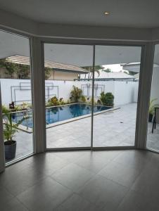 um quarto com portas de vidro deslizantes e uma piscina em The Oasis Villa Just 150m to the Beach em Koh Samui