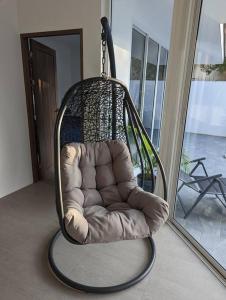 uma cadeira de baloiço está pendurada numa sala de estar em The Oasis Villa Just 150m to the Beach em Koh Samui