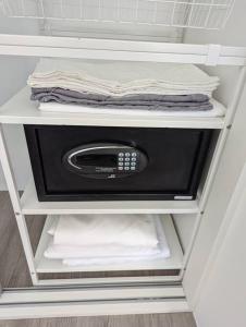 a refrigerator with a microwave on a shelf with towels at The Oasis Villa Just 150m to the Beach in Koh Samui