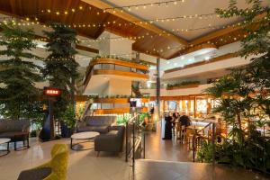 a lobby with tables and chairs and plants at Pavilion On Northbourne in Canberra