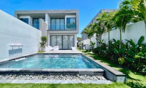 eine Villa mit einem Pool vor einem Haus in der Unterkunft PLAYA Villa in Sanctuary Resort - 100m from Private Beach - New 2023 in Hồ Tràm