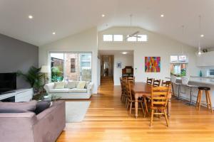 un soggiorno e una cucina con tavolo e sedie di Beach House Close to Manly a Sydney