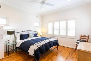 um quarto com uma cama com um edredão azul em Beach House Close to Manly em Sydney
