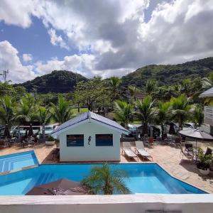 un complejo con piscina y palmeras en Paúba Beach Hotel, en Pauba