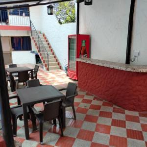 un restaurante con mesas y sillas y una pared roja en Hotel la Isabela By Marbar, en Villeta