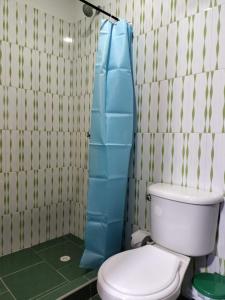 baño con aseo y cortina de ducha azul en Hotel la Isabela By Marbar, en Villeta