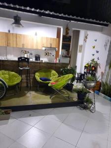 una habitación con sillas y una barra con plantas en Como en casa, en La Dorada