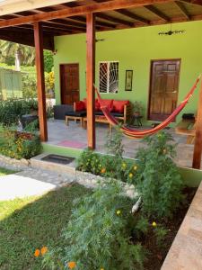 a patio with a hammock in a garden at Green Queendom Farm and Lodging in Oracabessa
