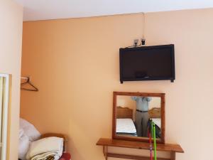 een kamer met een spiegel en een tv aan de muur bij Hotel maris in Ixtapan de la Sal