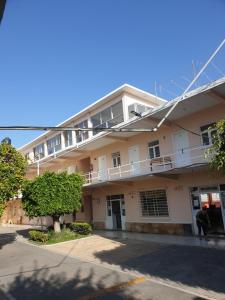 een groot wit gebouw met een boom ervoor bij Hotel maris in Ixtapan de la Sal